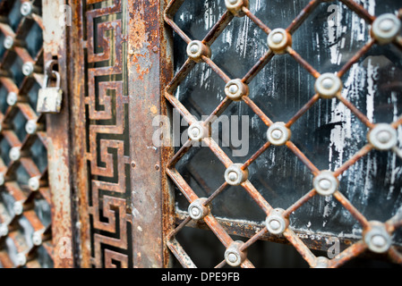 BUENOS AIRES, Argentinien – komplizierte geometrische Muster und ornamentale Muster zieren die verwitterten Eisentore der Mausoleen auf dem Recoleta-Friedhof (Cementerio de la Recoleta). Diese Metalldetails zeigen die raffinierte Handwerkskunst argentinischer und europäischer Handwerker aus dem 19. Jahrhundert. Trotz der Zeichen von Alter und Rost behalten die Tore ihre raffinierten dekorativen Elemente, die das reiche architektonische Erbe des Friedhofs demonstrieren. Stockfoto