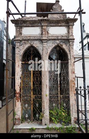 BUENOS AIRES, Argentinien – Gerüste umgibt ein sich verschlechterndes Mausoleum auf dem Recoleta-Friedhof (Cementerio de la Recoleta), was darauf hindeutet, dass die Erhaltung fortgesetzt wird. Die verzierte, aber zerbröckelnde Struktur veranschaulicht die Herausforderungen, die die Erhaltung der historischen Grabarchitektur mit sich bringt. Stockfoto