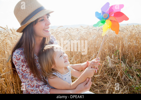Mutter und Tochter in Weizen Feld Holding Windmühle Stockfoto