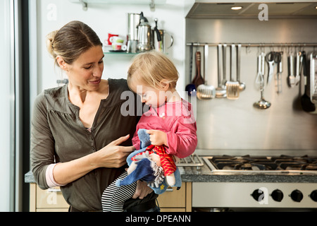 Mutter mit Baby-Mädchen in der Küche Stockfoto