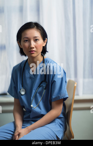 Porträt einer jungen Ärztin, die im Büro sitzen Stockfoto