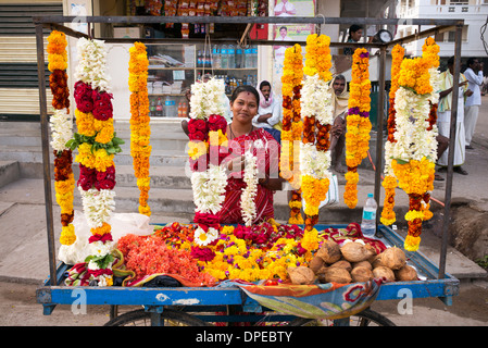 Indische Frau verkaufen Blumen und Girlanden für Hindutempel Verehrung. Puttaparthi, Andhra Pradesh, Indien Stockfoto