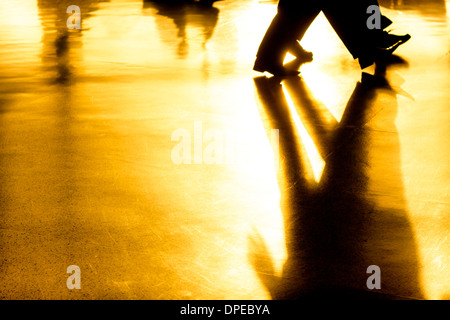 Abstrakte kreatives Foto von Menschen Silhouetten von Menschen und ihren Schatten auf goldenem Hintergrund Stockfoto