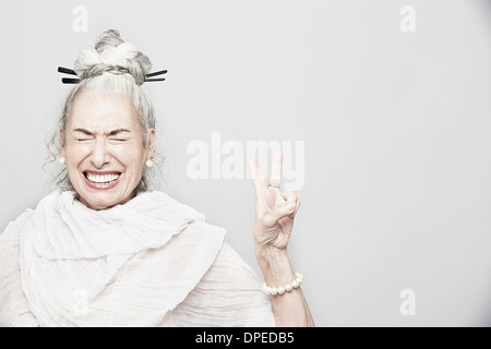 Studioportrait für anspruchsvolle senior Frau Victory-Zeichen machen Stockfoto