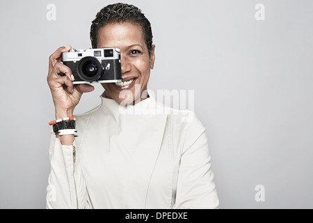 Studioportrait glücklich Reife Frau mit Kamera Stockfoto