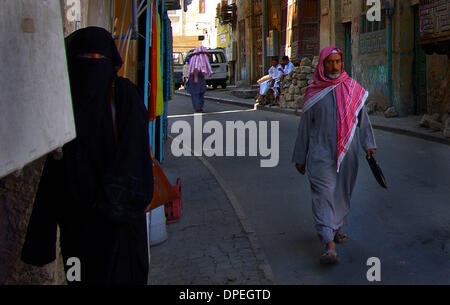 (Veröffentlicht 22.12.2002, a-1): NC SAUDI X001... 12. Dezember 2002, Jeddah, Saudi Arabien...  Tragen die traditionelle Frau Kleidung genannt Abaya wartet eine saudische Frau direkt vor einem lokalen Händler Textilgeschäft in den alten Stockfoto
