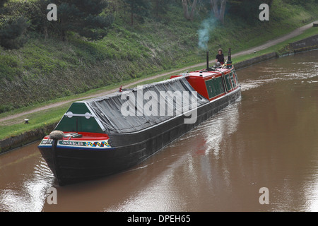 Eine traditionelle Arbeiten Narrowboat nähert sich Lock 8 von den Audlem Flug von Sperren auf dem Shropshire-Union-Kanal Stockfoto