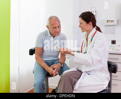Ärztin im Gespräch mit älteren männlichen Patienten Stockfoto