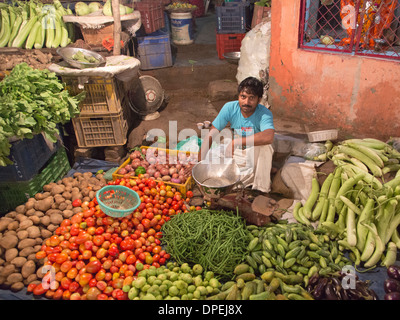 Indischer Mann, Verkauf von Gemüse auf dem Boden in einem Straßenmarkt in Neu-Delhi in der Nacht, Indien Stockfoto