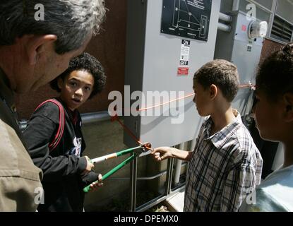 (Veröffentlichte 15.05.2005, e-3) BJ Bonner, Center, Präsident der Fachschaft, schneidet die Drähte, die die Platten für das neue Photovoltaik Solar Dach-System in San Diego City Schools' Education Center am Montag zu beschränken. Bonner, ein Fünftklässler an Alice Birney Grundschule, blickte zurück zu Bob Martin, links, SDCSs Energie- und Versorgungswirtschaft Managements. Rechts ist die Bonner Klassenkamerad Stockfoto