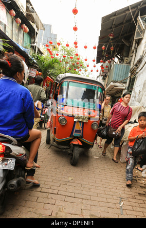 Ein Bajaj (Tuk Tuk) fahren in einer kleinen Straße in Jakarta Chinatown, bekannt als Glodok, Indonesien. Jakarta ist eine sehr dicht besiedelte Stadt Stockfoto