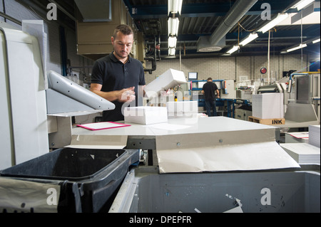 Arbeiter, die Maschine in der Druckwerkstatt Papier vorbereiten Stockfoto