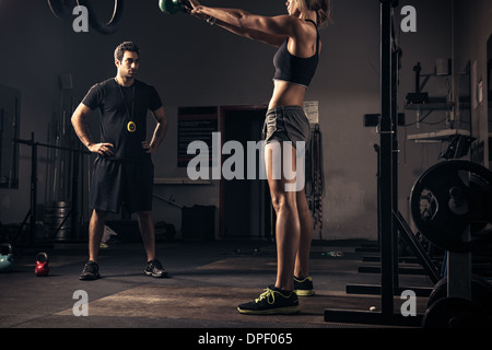 Weibliche Gewichtheber von Trainer beobachtet Stockfoto