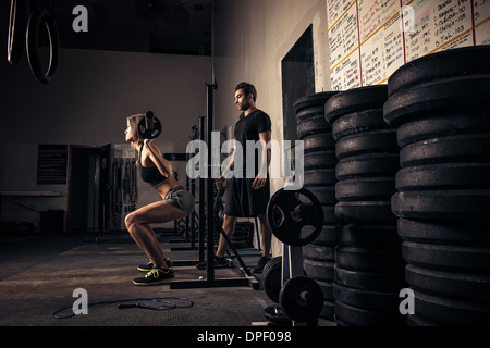 Weibliche Gewichtheber von Trainer beobachtet Stockfoto