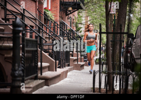 Frau, jogging am Bürgersteig Stockfoto