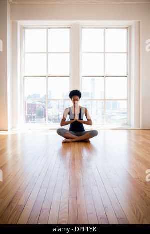 Frau praktizieren Yoga im Raum Stockfoto