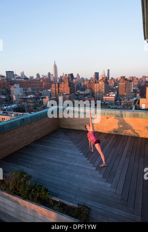 Frau praktizieren Yoga auf Dach Stockfoto