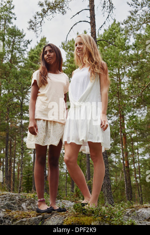 Porträt von Mädchen im Teenageralter stehen auf Felsen im Wald Stockfoto