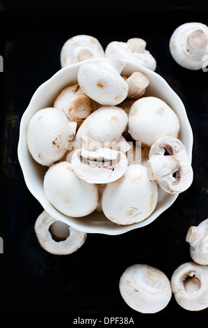 Schüssel mit Champignons auf schwarzem Hintergrund Stockfoto