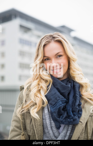 Lächeln auf den Lippen trendigen Blondine posiert im freien Stockfoto