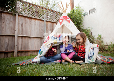 Drei junge Mädchen in einem Garten Versteck unter Decke Stockfoto