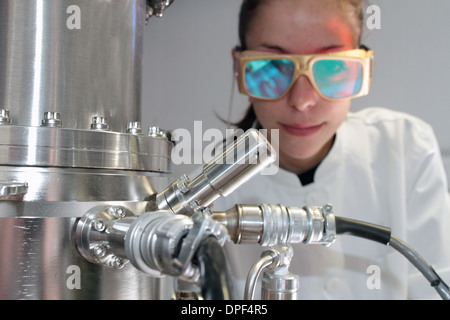 Wissenschaftlerin, die Überwachung der wissenschaftlichen Geräte im Labor Stockfoto