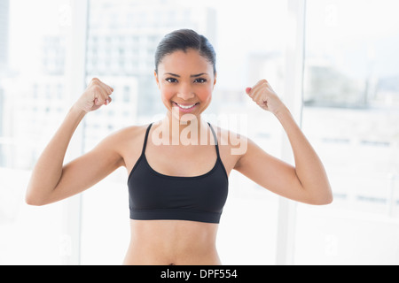 Dunklen Haaren Erfolgsmodell in Sportbekleidung zeigt ihre Stärke Stockfoto