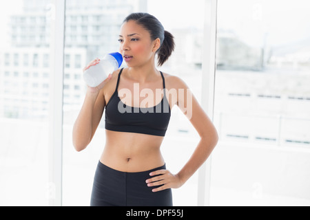 Charmante dunklen Haaren Modell im Sportswear-Trinkwasser Stockfoto