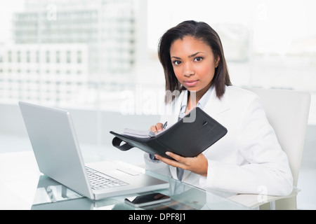 Schwere jungen dunklen Haaren Geschäftsfrau füllen ihr Zeitplan Stockfoto