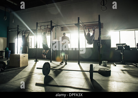 Drei Männer, die Schulungen zur Übung Bar im gymnasium Stockfoto