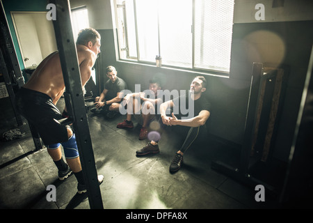 Trainer im Gespräch mit der Gruppe von Männern im gymnasium Stockfoto