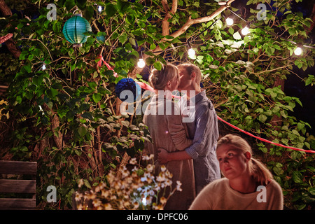 Junges Paar umarmt bei Garten-Party in der Nacht Stockfoto