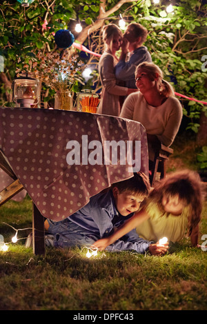 Schelmische Kinder Garten-Party in der Nacht genießen Stockfoto