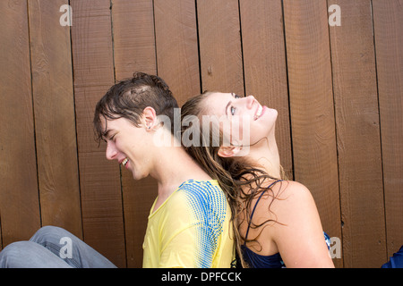 Junges Paar sitzt vor Gartenzaun Stockfoto