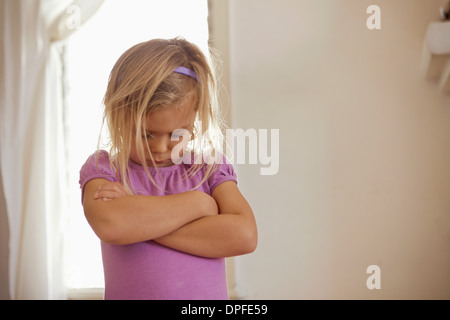 Junges Mädchen mit Kopf und Armen gefaltet mit Wutanfall Stockfoto