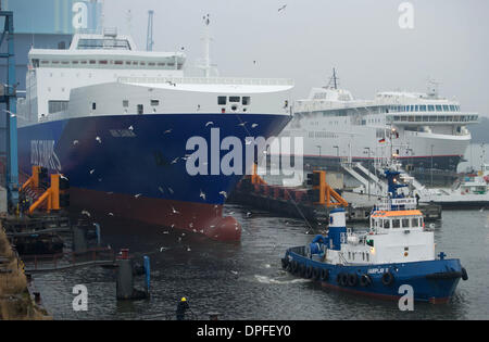 Stralsund, Deutschland. 14. Januar 2014. Das letzte neue Schiff in P S-Werft Volkswerft Stralsund, einem Spezialtransporter 'Roll on - Roll-off Cargo' mit der Fabriknummer 501 für die dänische Reederei DFDS, der das Schiffshebewerk von Schlepp Boote vor der Schiffbauhalle der insolventen Shopyard P S-Werft Volkswerft in Stralsund, Deutschland, 14. Januar 2014 gezogen wird gebaut werden. Dänische Reederei DFDS a/s hat zwei Transportschiffe in Stralsund bestellt. Foto: STEFAN SAUER/Dpa/Alamy Live News Stockfoto