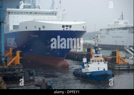 Stralsund, Deutschland. 14. Januar 2014. Das letzte neue Schiff in P S-Werft Volkswerft Stralsund, einem Spezialtransporter 'Roll on - Roll-off Cargo' mit der Fabriknummer 501 für die dänische Reederei DFDS, der das Schiffshebewerk von Schlepp Boote vor der Schiffbauhalle der insolventen Shopyard P S-Werft Volkswerft in Stralsund, Deutschland, 14. Januar 2014 gezogen wird gebaut werden. Dänische Reederei DFDS a/s hat zwei Transportschiffe in Stralsund bestellt. Foto: STEFAN SAUER/Dpa/Alamy Live News Stockfoto