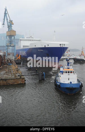 Stralsund, Deutschland. 14. Januar 2014. Das letzte neue Schiff in P S-Werft Volkswerft Stralsund, einem Spezialtransporter 'Roll on - Roll-off Cargo' mit der Fabriknummer 501 für die dänische Reederei DFDS, der das Schiffshebewerk von Schlepp Boote vor der Schiffbauhalle der insolventen Shopyard P S-Werft Volkswerft in Stralsund, Deutschland, 14. Januar 2014 gezogen wird gebaut werden. Dänische Reederei DFDS a/s hat zwei Transportschiffe in Stralsund bestellt. Foto: STEFAN SAUER/Dpa/Alamy Live News Stockfoto