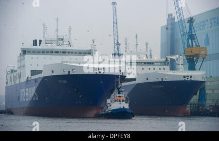 Stralsund, Deutschland. 14. Januar 2014. Das letzte neue Schiff in P S-Werft Volkswerft Stralsund, einem Spezialtransporter 'Roll on - Roll-off Cargo' mit der Fabriknummer 501 (L) für die dänische Reederei DFDS, der das Schiffshebewerk von Schlepp Boote vor der Schiffbauhalle der insolventen Shopyard P S-Werft Volkswerft in Stralsund, Deutschland, 14. Januar 2014 gezogen wird gebaut werden. Dänische Reederei DFDS a/s hat zwei Transportschiffe in Stralsund bestellt. Foto: STEFAN SAUER/Dpa/Alamy Live News Stockfoto