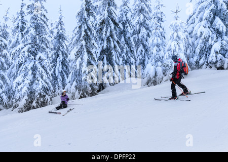 Ski Patrol Hilfe verletzte Frau Skifahrer im Schnee liegend zu retten Stockfoto