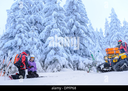 Ski Patrol hilft Frau mit gebrochenen Arm Rettung quad Stockfoto