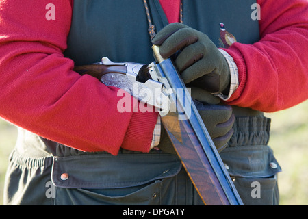 A Mann, laden 12 Bohrung oder Schrotflinte auf einem Fasan schießen in England zu messen Stockfoto