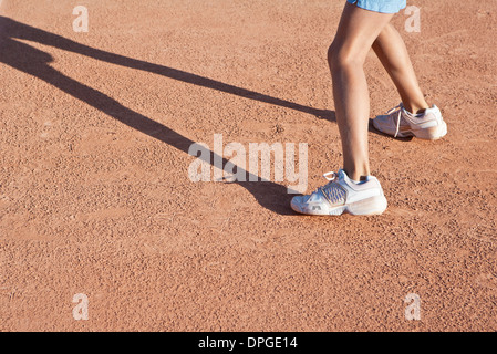 Kind stehend auf Tennisplatz, niedrig, Abschnitt Stockfoto