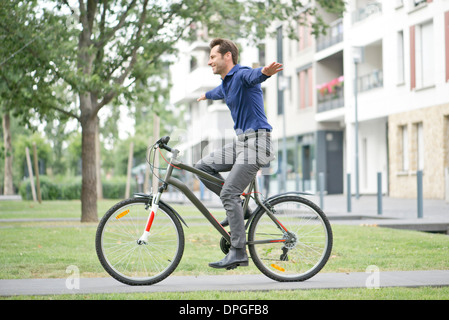 Mann Reiten Fahrrad mit ausgestreckten Armen Stockfoto