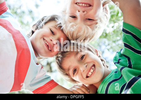 Jungen kauern, nach unten in die Kamera Lächeln Stockfoto