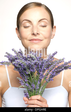 Frau riechen Duft von frischem Lavendel mit Augen geschlossen Stockfoto