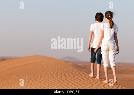 Bruder und Schwester zu Fuß auf Sand Dune, Rückansicht Stockfoto