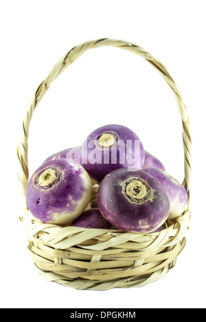 violette Leitung Steckrüben in Stroh Korb auf weißem Hintergrund (Schneidepfad Arbeit inbegriffen). Stockfoto