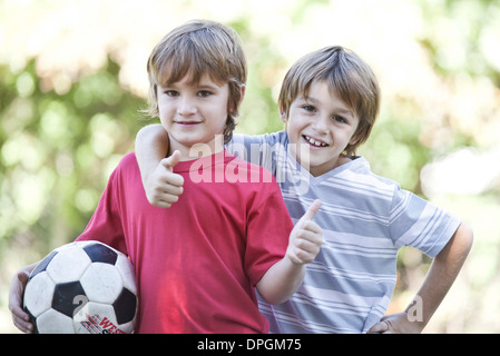 Jungen mit Fußball, hält Daumen hoch, Porträt Stockfoto