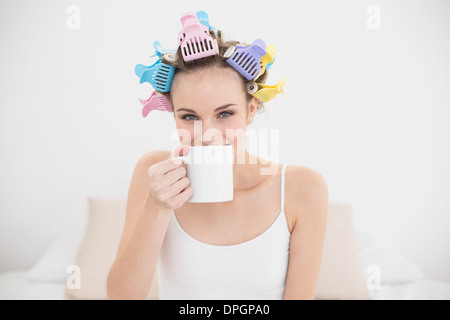 Freuen uns natürliche braune kurzhaarige Frau in Lockenwicklern genießen Kaffee Geruch Stockfoto